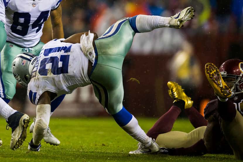 Dallas Cowboys running back Ezekiel Elliott (21) flies sideways after a Washington Redskins...