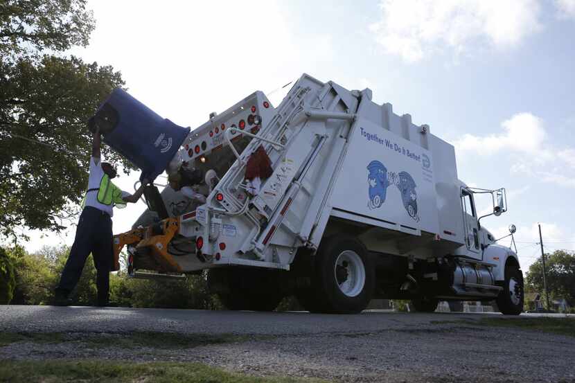 Darrell Kennedy unloads a recycling bin for the city of Dallas in a South Dallas neighborhood.