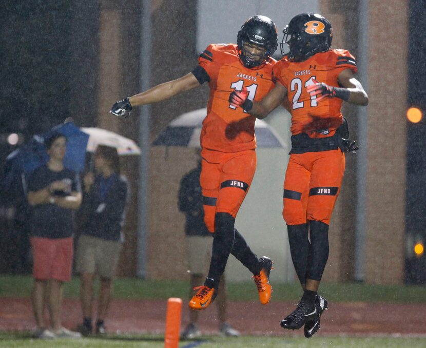 FILE - Rockwall's Jaxon Smith (11) and Alex Orji (21) perform a celebratory bump in the end...