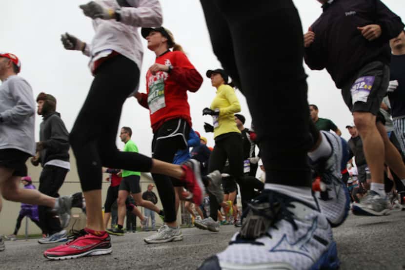 Runners make their way past the starting line at the MetroPCS Dallas White Rock Marathon,...