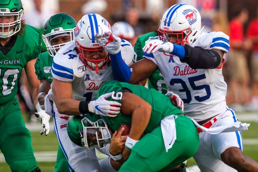 North Texas quarterback Mason Fine (6) is sacked by SMU linebacker Richard Moore (14) and...