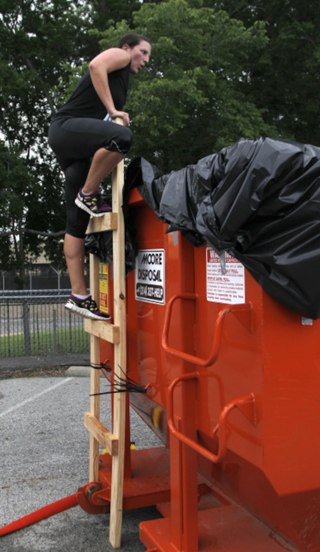 Kara Noah climbs into a dumpter during the Second Annual Fair Park 5K Urban Dash Saturday...