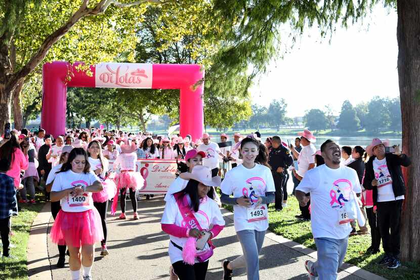 Participants run during the Di'Lolas breast cancer awareness run at Bachman Lake Park in...