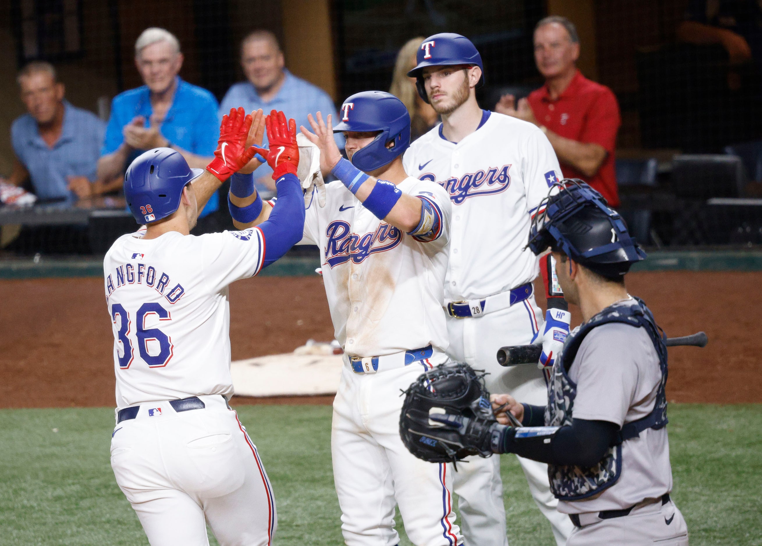 Texas Rangers outfielder Wyatt Langford (36) celebrates with his teammate Josh Jung (6)...