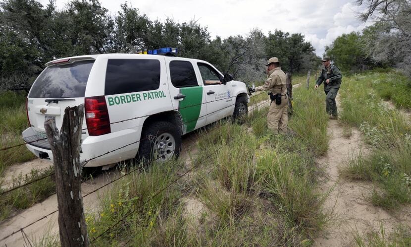 U.S. Customs and Border Protection agents confer as they patrol near McAllen in South Texas....