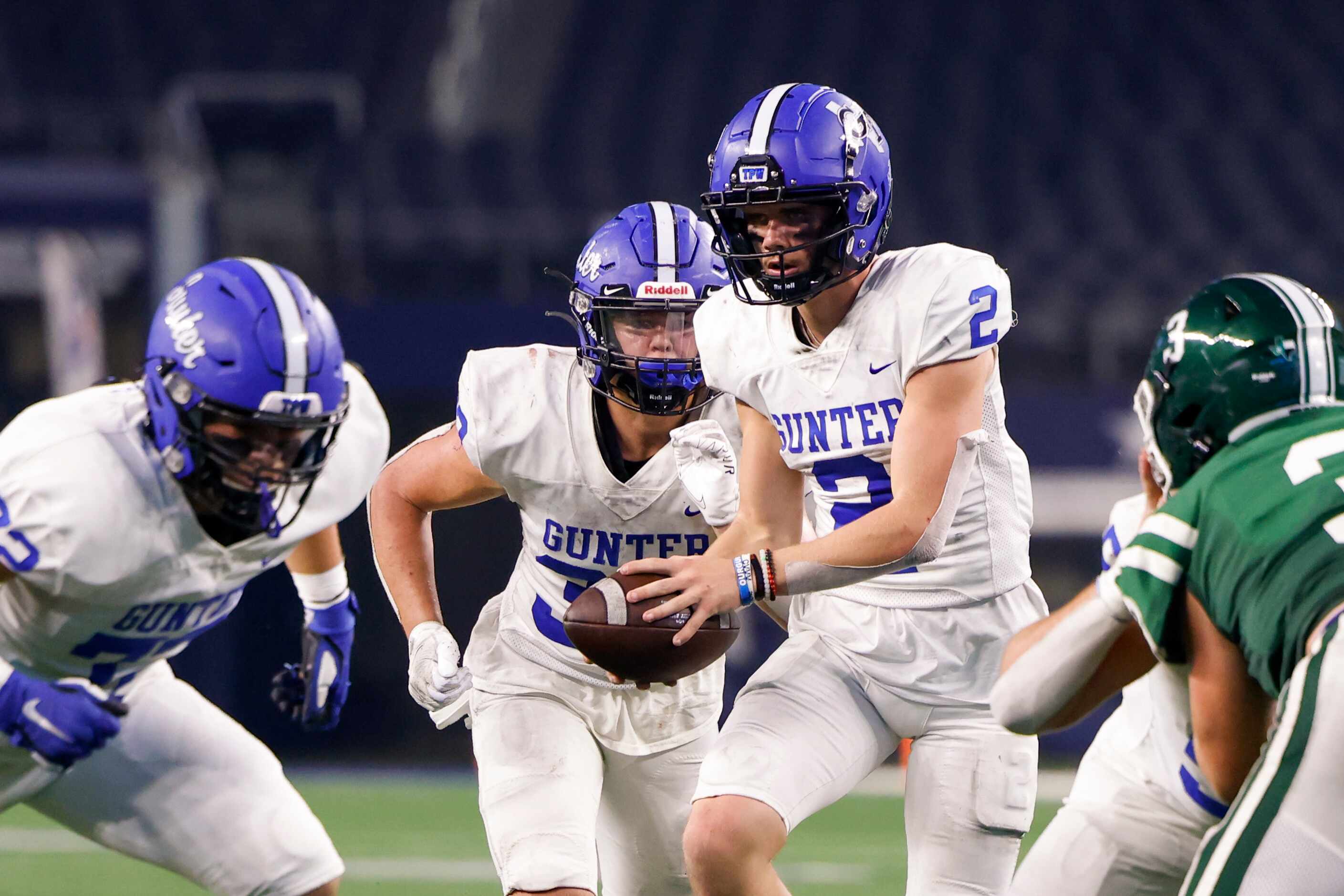 Gunter quarterback Hudson Graham (2) hands the ball to Gunter running back Brayden Hinton...