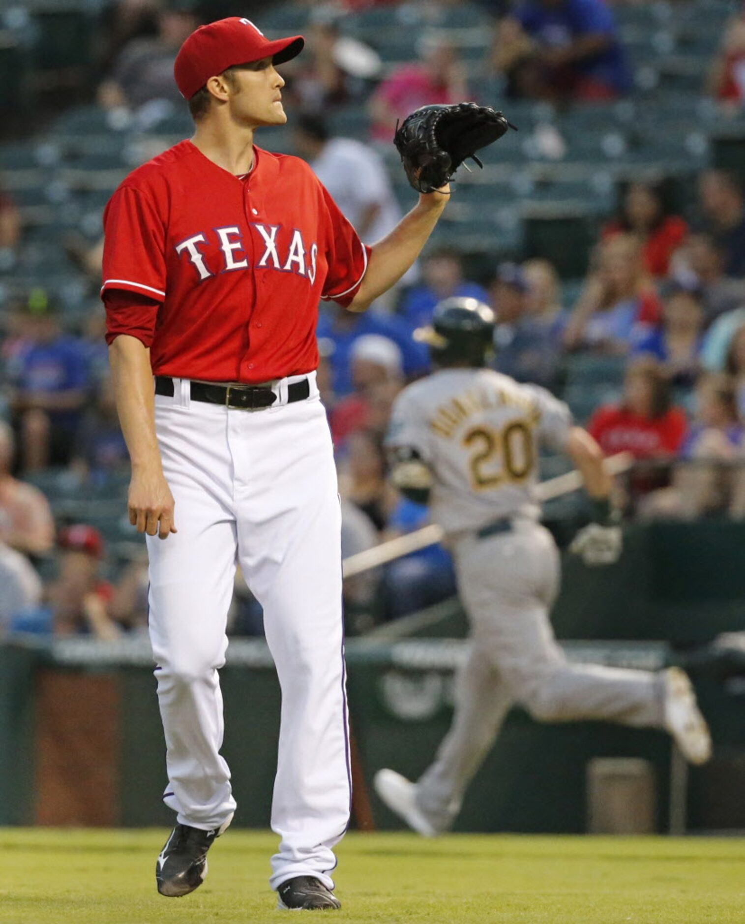 Texas starting pitcher asks for a new ball as Oakland's Josh Donaldson rounds first after...