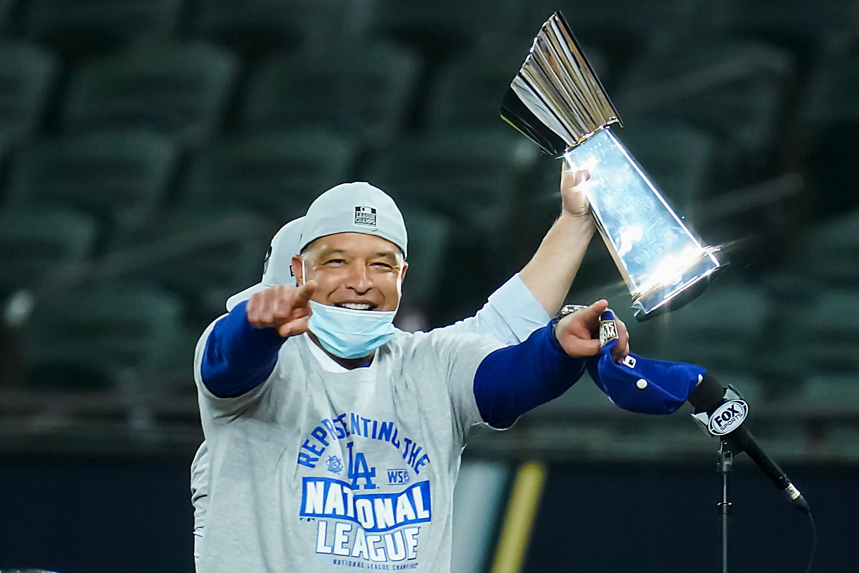 Los Angeles Dodgers mangers Dave Roberts celebrates with the championship trophy after a 4-3...