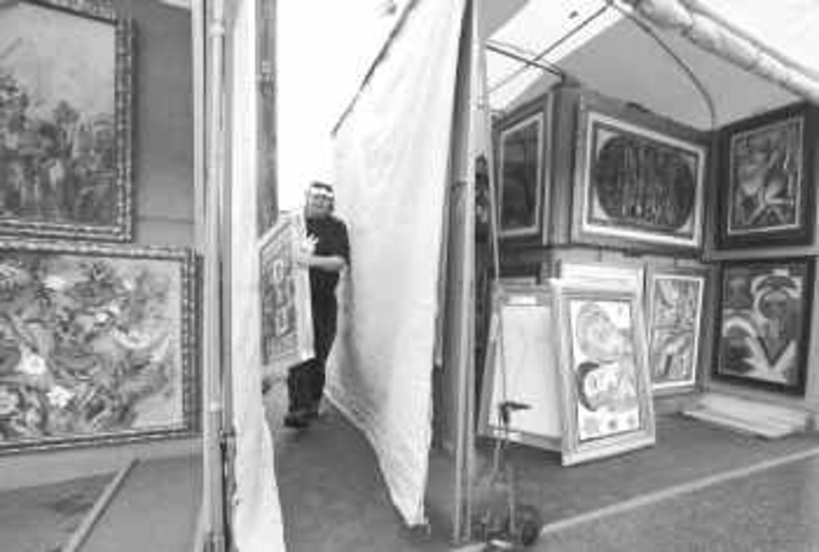  Billy Overton carries paintings by Houston artist Guiteau Lanoue from a truck to Lanoue's...