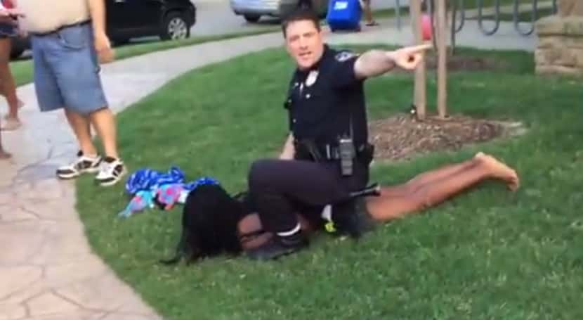 McKinney police Officer Eric Casebolt warns others away as he kneels on a female teen as he...