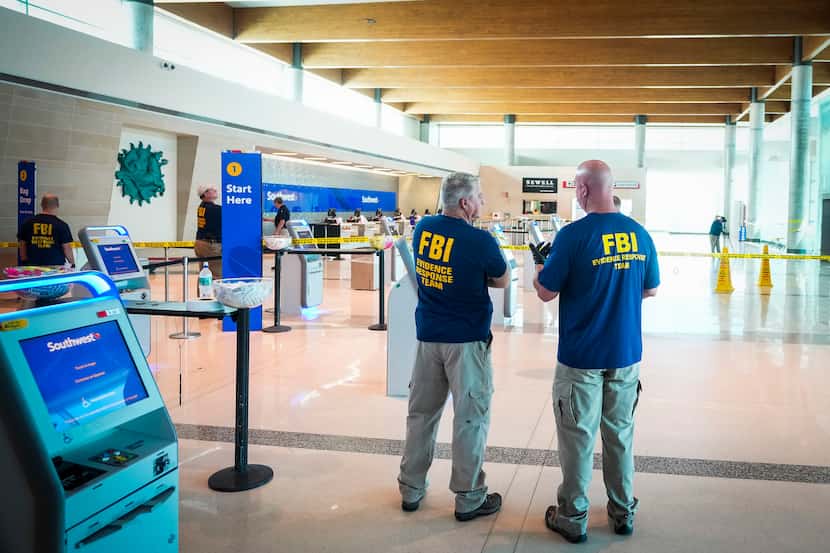 An FBI Evidence Response Team works inside the ticketing hall at Dallas Love Field Airport...