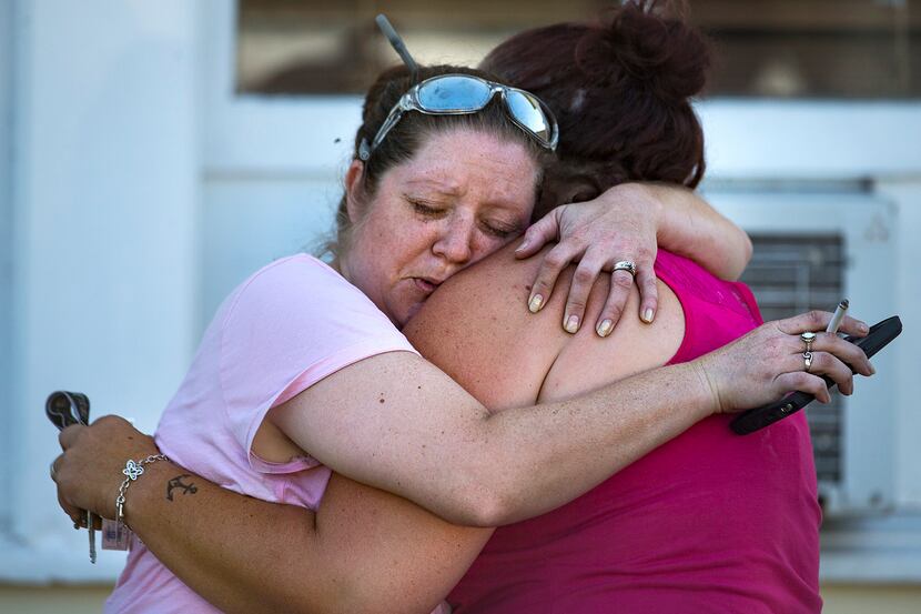 Carrie Matula embraces a woman after a fatal shooting at the First Baptist Church in...