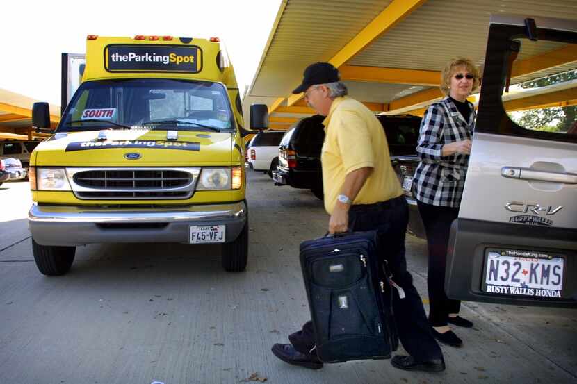 The Parking Spot driver James Rogers helps Deborah Grotke of Dallas load her bags onto a...