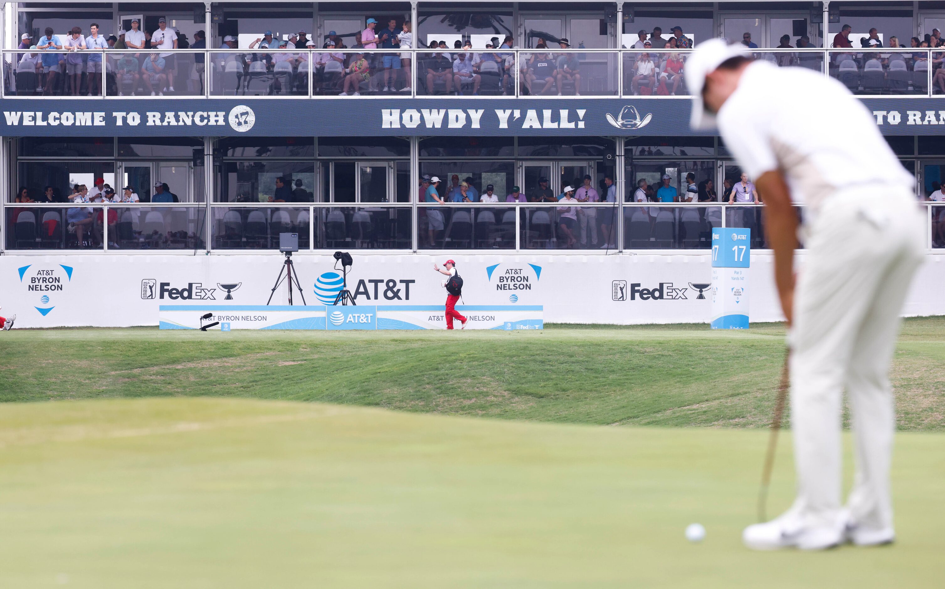 People gather at the 17th hole as S.Y. Noh of South Korea putts during the second round of...