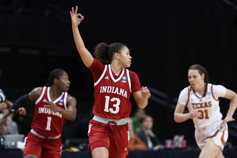 Indiana's Jaelynn Penn, center, signals her 3-point shot as she runs down court near Sug...