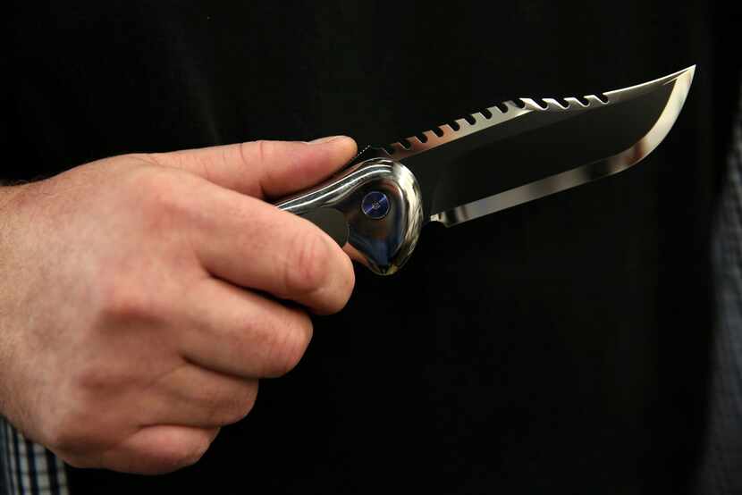 Todd Begg holds the Baker Team knife, modeled after the Rambo knife, he crafted at his shop...