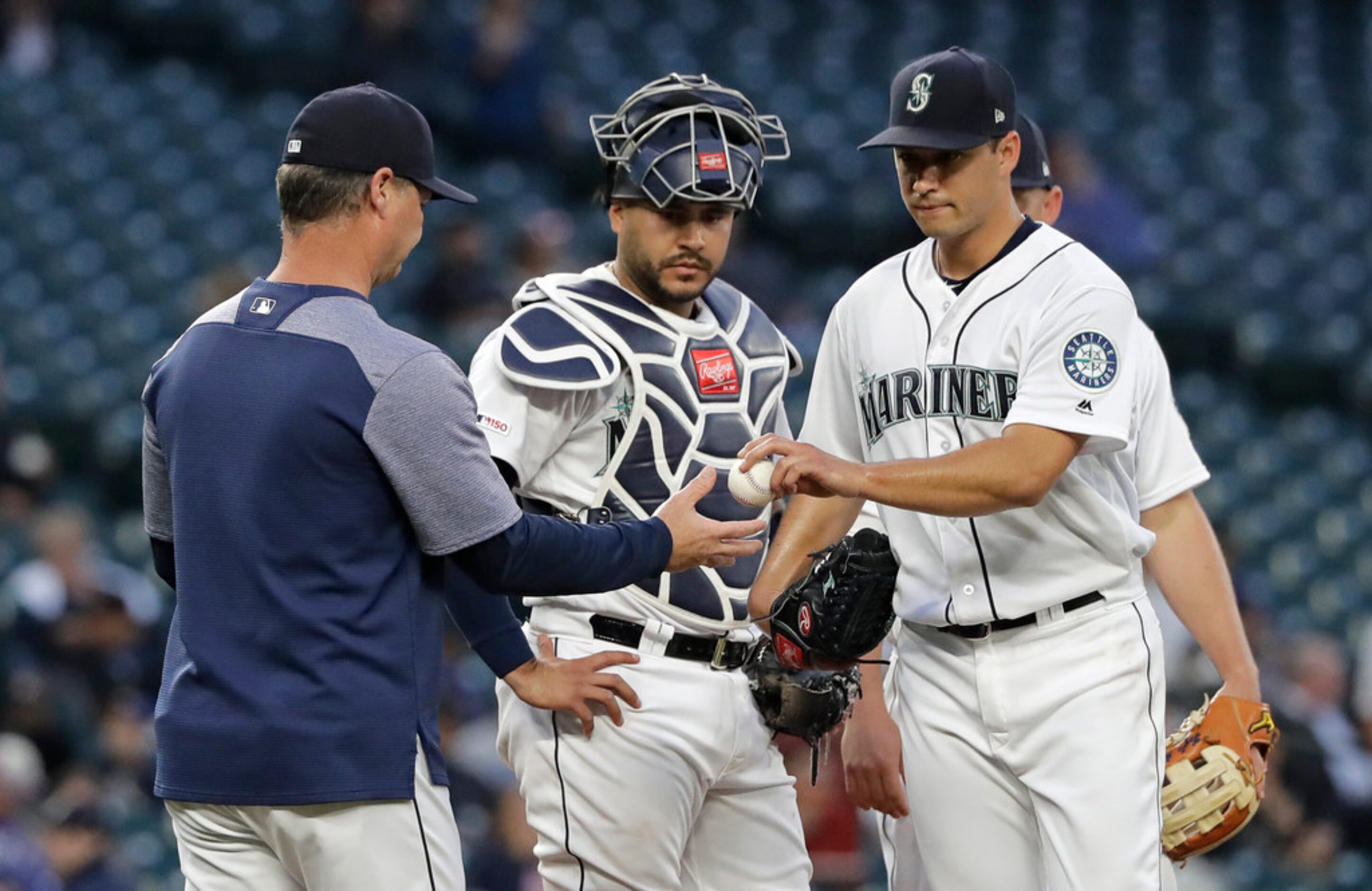 Seattle Mariners starting pitcher Marco Gonzales, right, hands the ball to manager Scott...