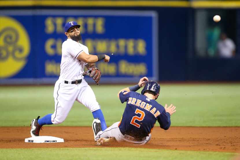 Texas Rangers second baseman Rougned Odor turns a double play over the Houston Astros' Alex...