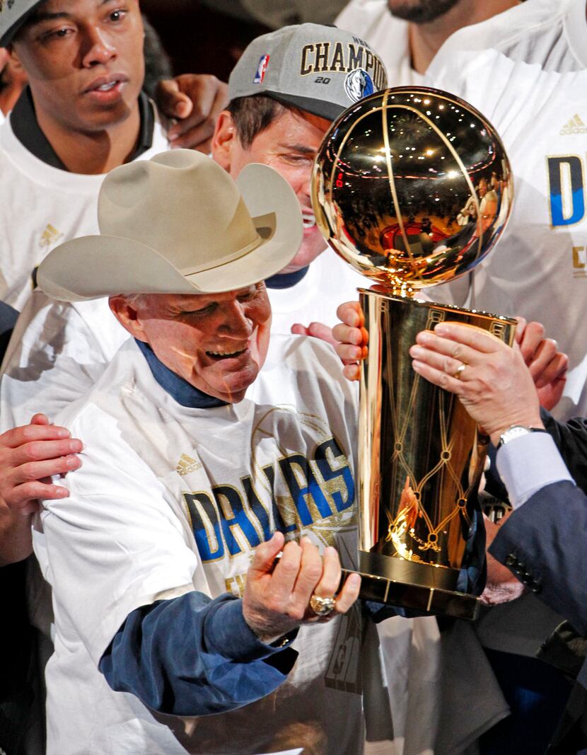 Dallas Mavericks original owner Don Carter (in cowboy hat) is handed the Larry O'Brien NBA...