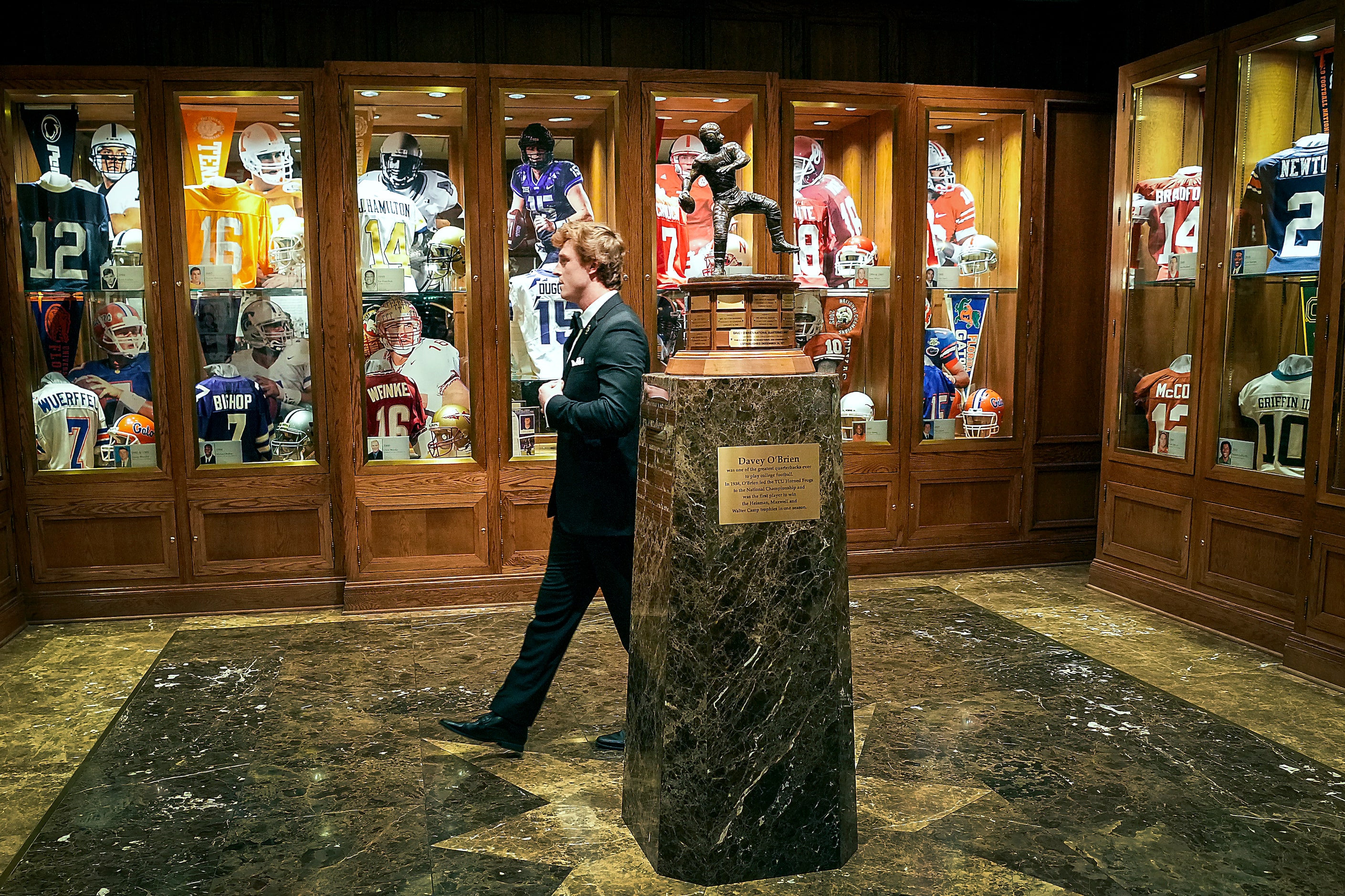 TCU quarterback Max Duggan buttons his jacket as he prepared to have his photo taken with...