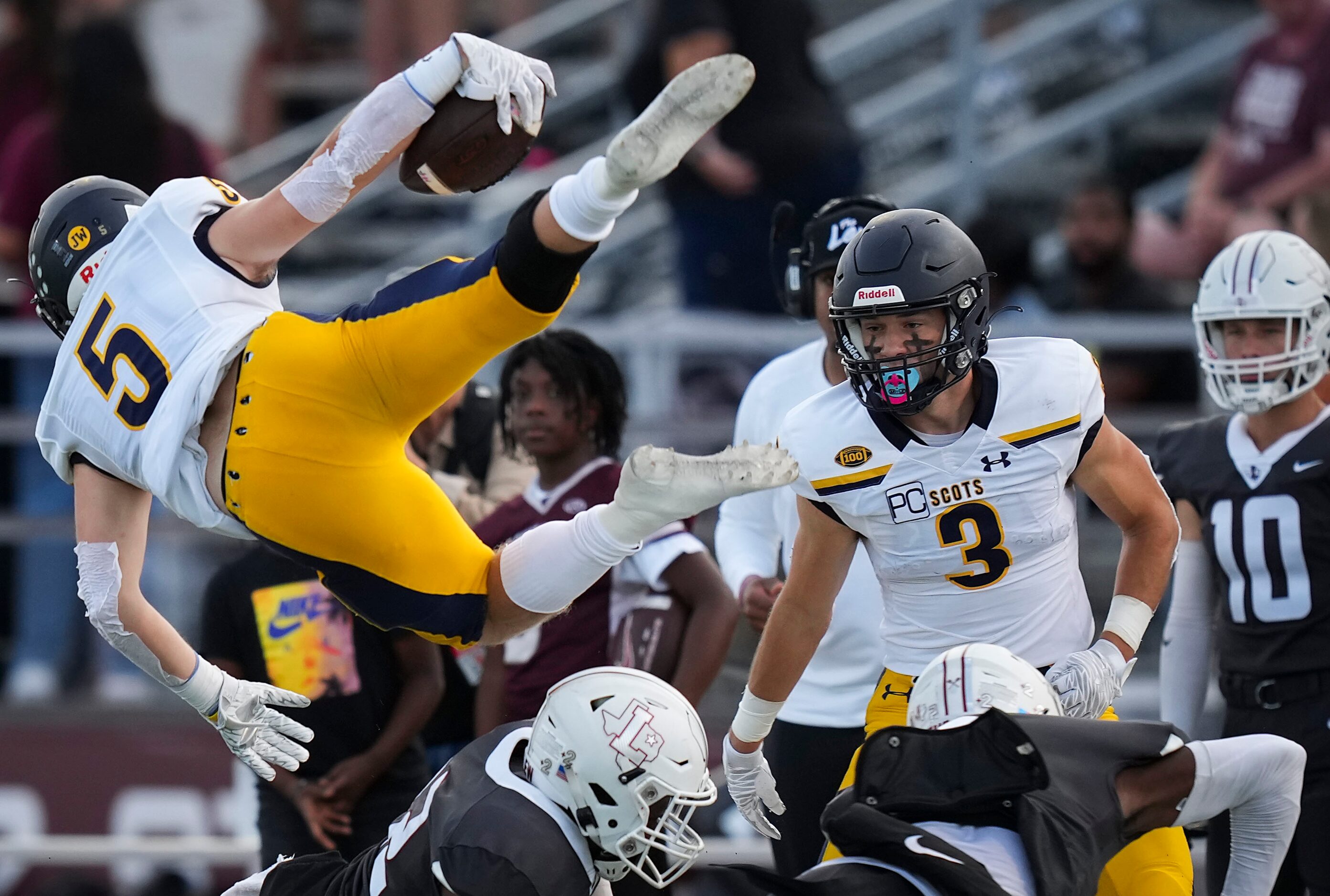 Highland Park running back Jay Cox (5) flies over Lewisville defensive backs Jordan Johnson...