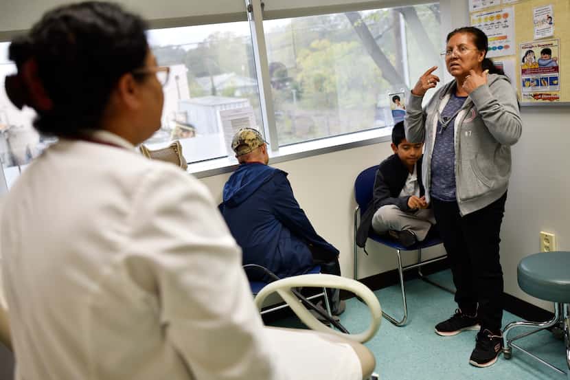 Nurse Practitioner Jhudy Mohan (left) listened as Maria Martinez described her son's...