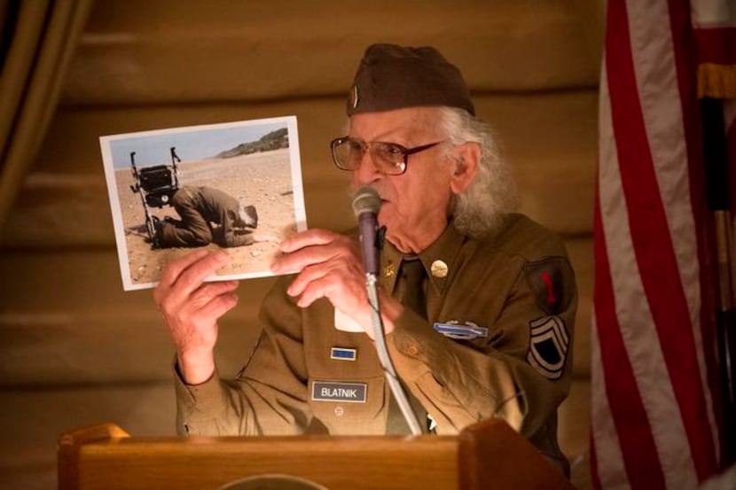 
World War II veteran Robert Blatnik shows a picture of himself kneeling on a Normandy beach...