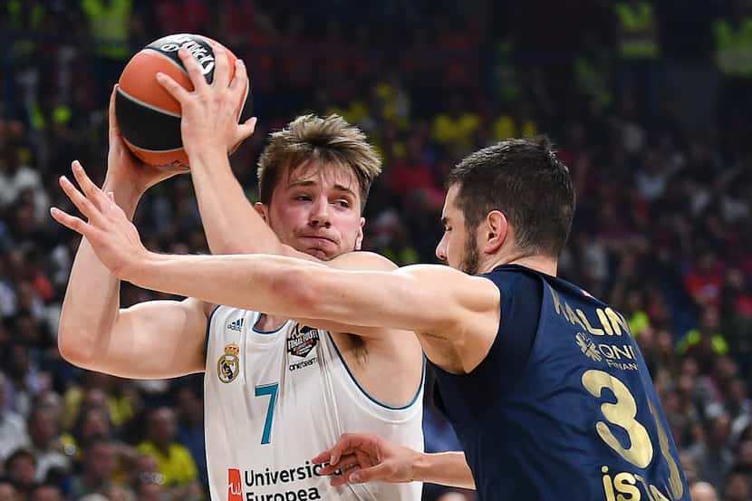 Real Madrid's Slovenian Luka Doncic (L) fights for the ball with Fenerbahce's Serbian...