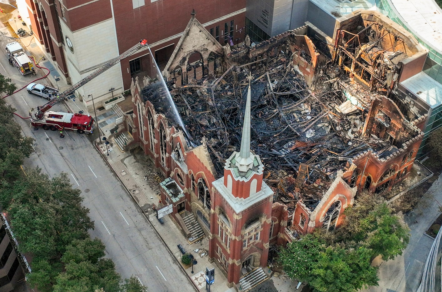 Dallas firefighters spray water on hotspots at First Baptist Dallas church in downtown...