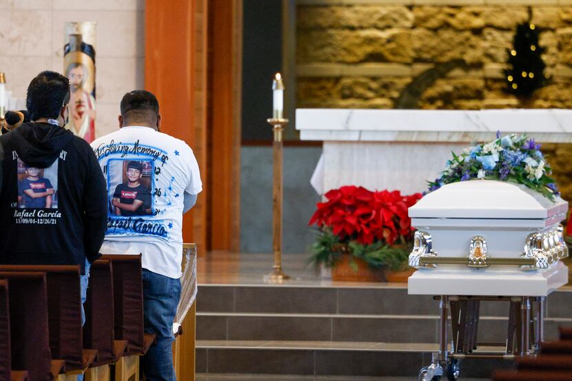 Family and friends stand during a funeral Mass for Rafael García at Good Shepherd Catholic...