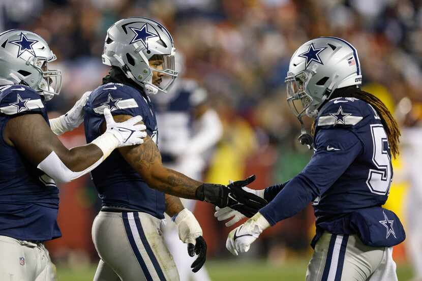 Dallas Cowboys linebacker Micah Parsons (11) high-fives linebacker Buddy Johnson (57) after...