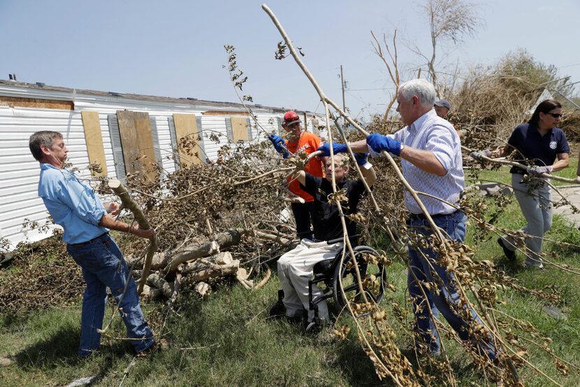 Vice President Mike Pence (center right) and Gov. Greg Abbott (in wheelchair) help move...