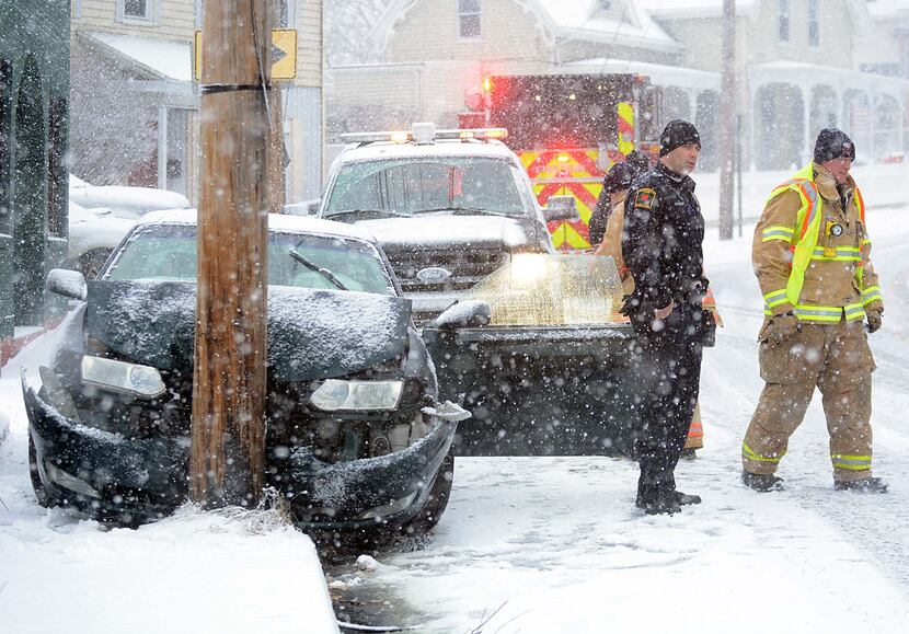  Norwich police and fire personnel respond to a car that slid into a pole Saturday, Jan. 23,...