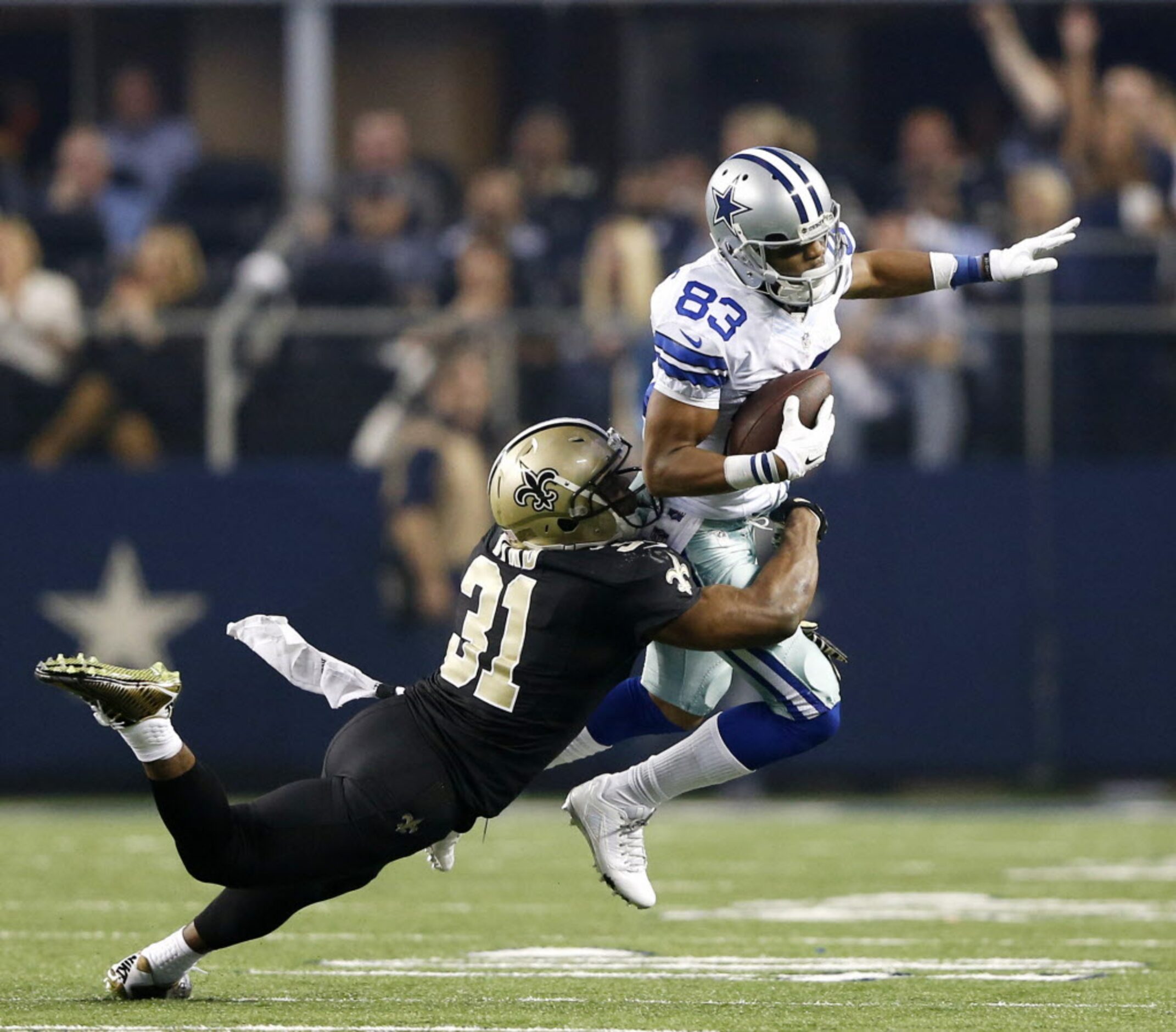 Dallas Cowboys wide receiver Terrance Williams (83) is brought down by New Orleans Saints...