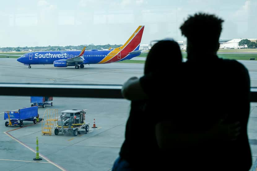 A couple watched as a Southwest Airlines flight taxied to the gate at Dallas Love Field on...