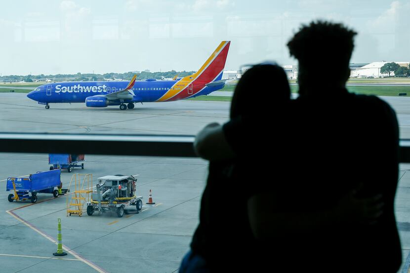 A couple watched as a Southwest Airlines flight taxied to the gate at Dallas Love Field on...