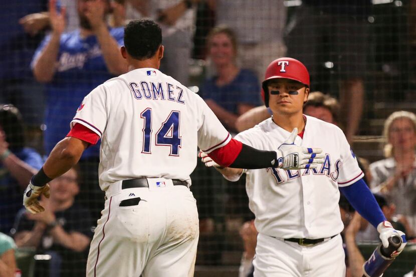 Texas Rangers' Carlos Gomez (14) celebrates with Shin-Soo Choo (17) after scoring against...