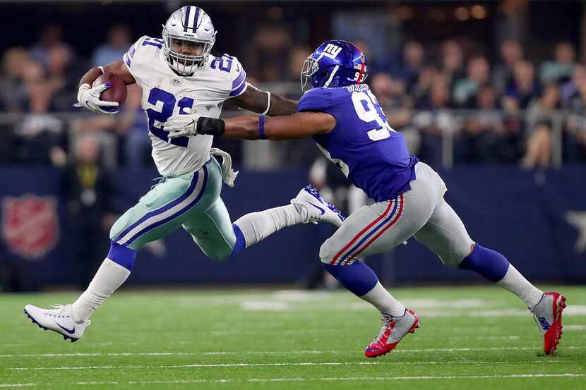 Ezekiel Elliott of the Dallas Cowboys carries the ball under pursuit by B.J. Goodson of the...