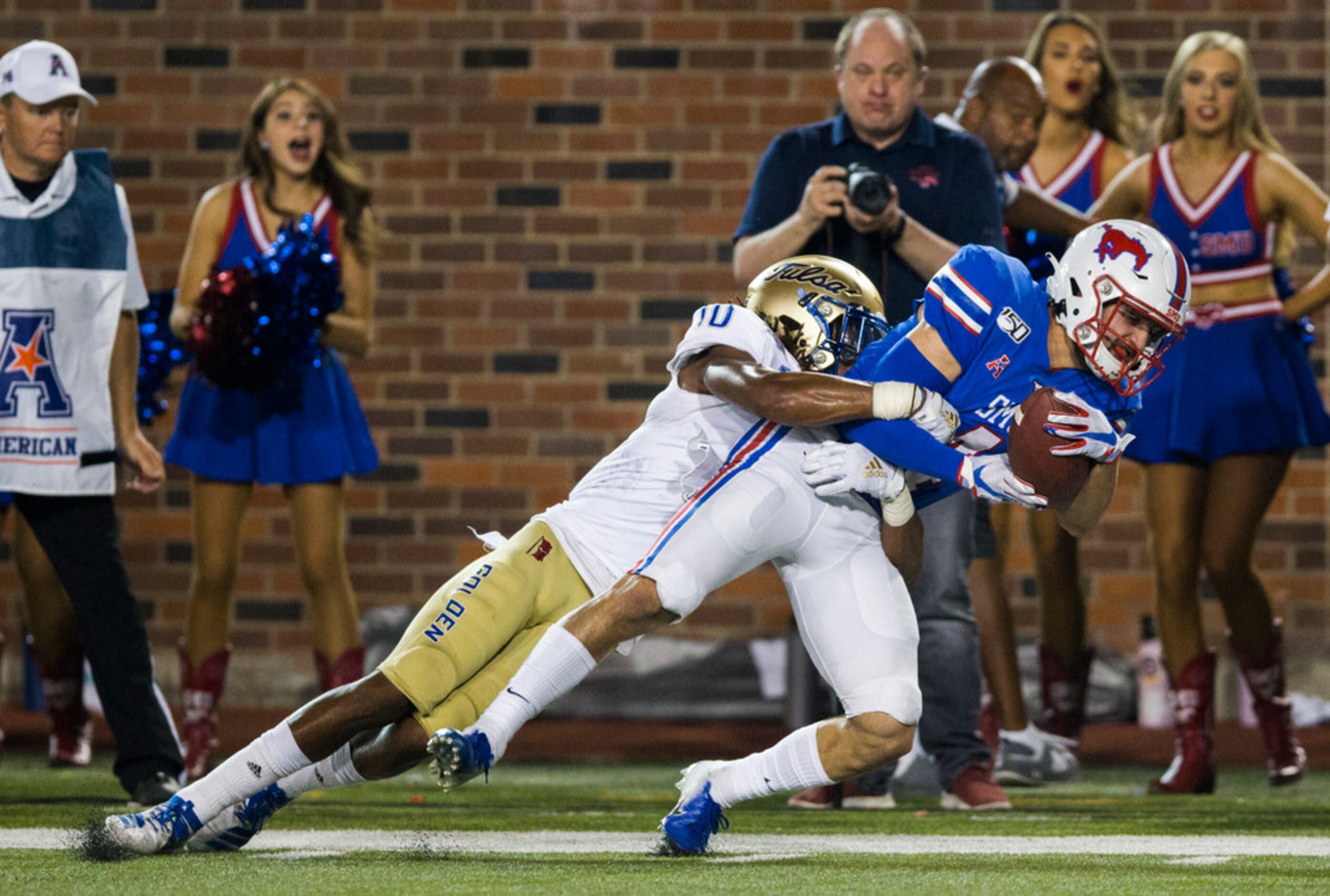 SMU Mustangs wide receiver Tyler Page (4) is tackled by Tulsa Golden Hurricane safety Manny...