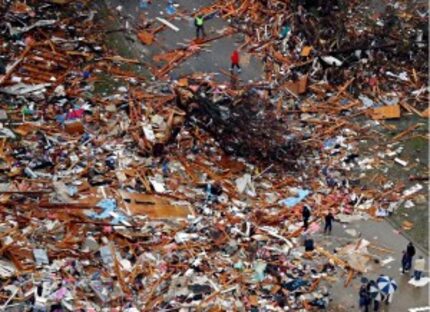  People surveyed tornado-damaged homes Sunday in Rowlett. Violent storms ripped through...