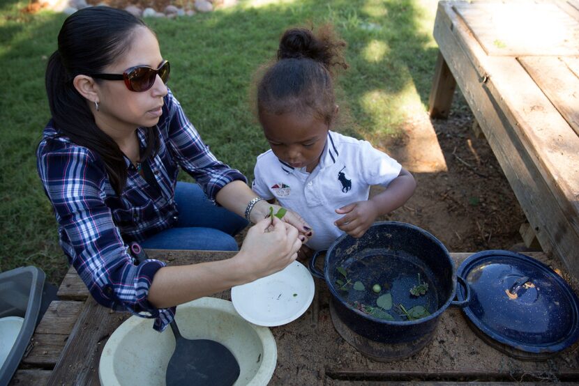 Teacher Jamie Lenenberg works with Braylen Griffin in the Vogel Alcove garden. The garden is...