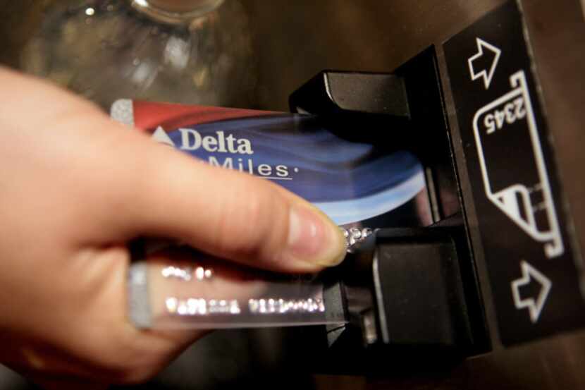 In this Dec. 14, 2007 file photo, a traveler uses a Delta Airlines credit card to buy an...