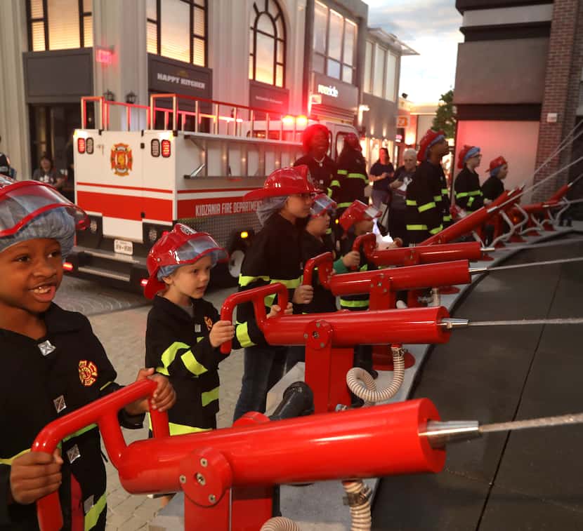Children play as firefighters at Stonebriar Centre's KidZania, an interactive entertainment...
