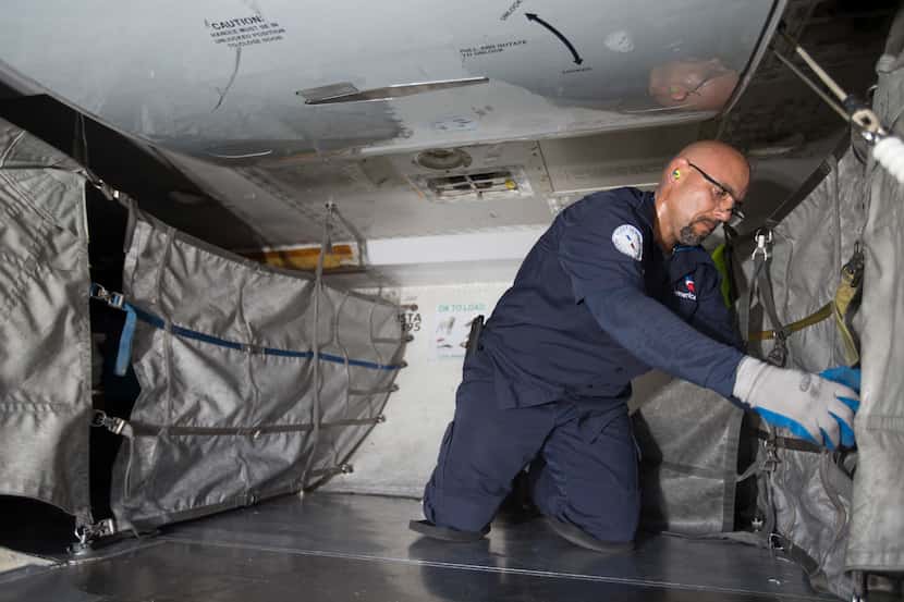 An American Airlines fleet worker loads cargo onto a plane.