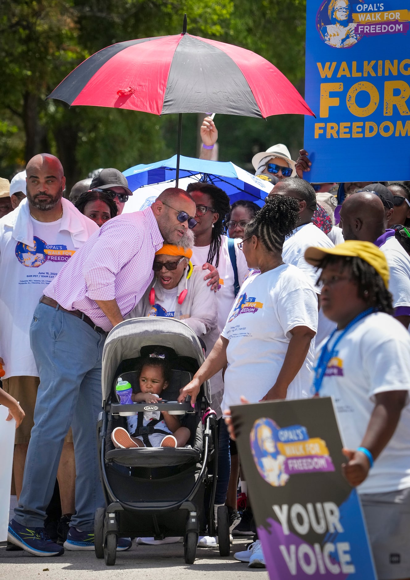 Opal Lee pause her walk, while pushing one of her great granddaughters in a stroller, to get...