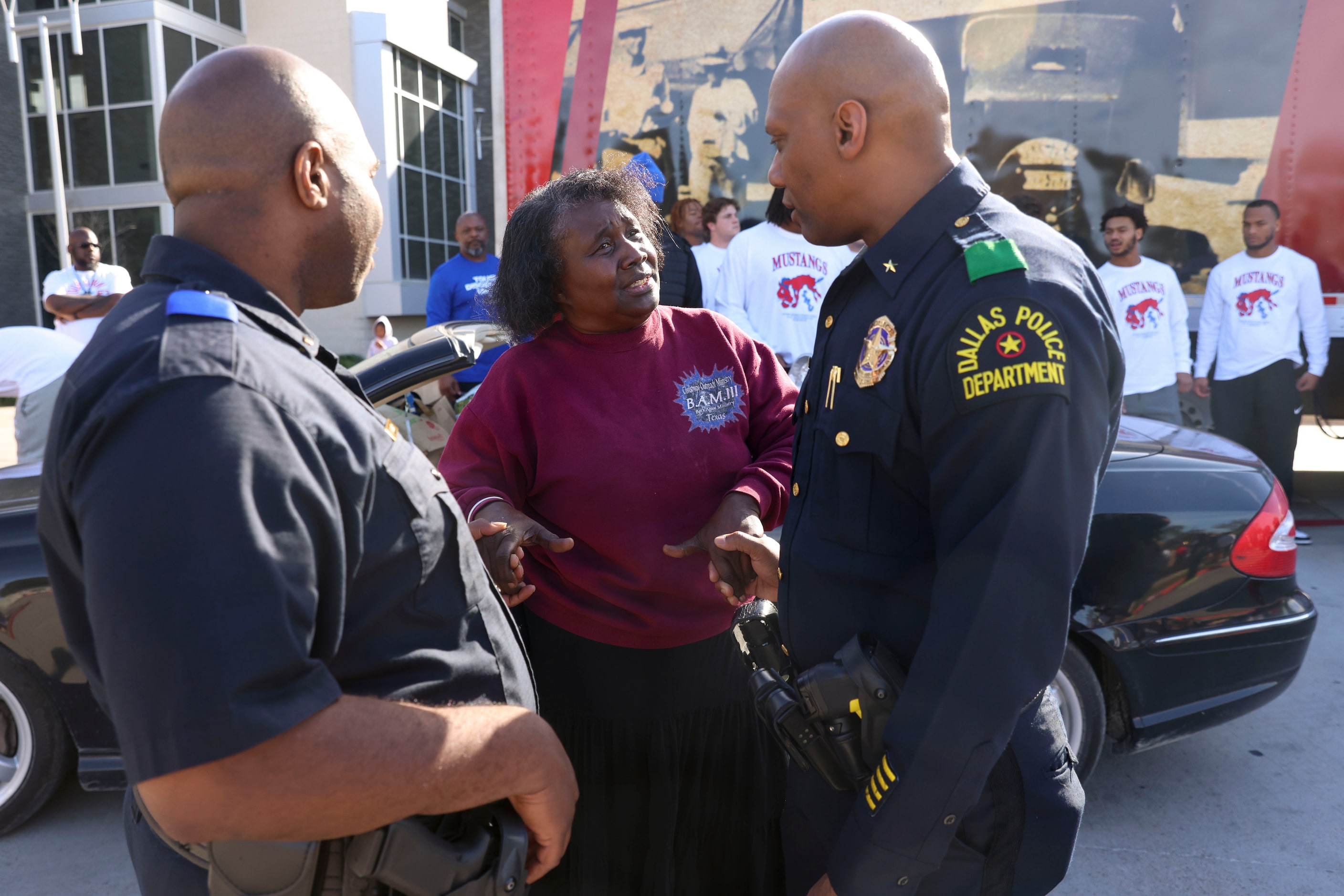 Pamela Booth gets down from her car and talks to Dallas Police Department officers during a...