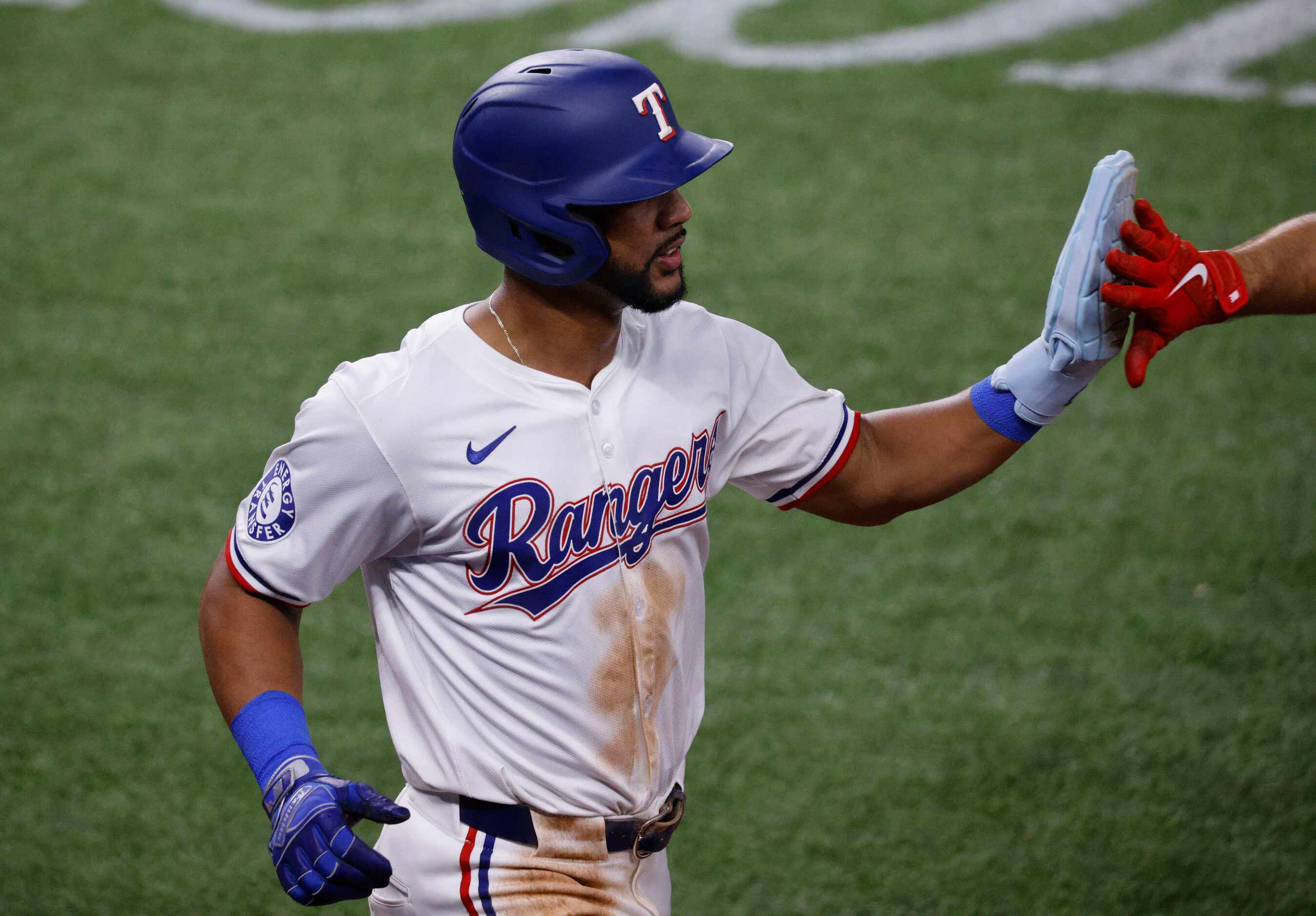 Texas Rangers outfielder Leody Taveras (3) gets a high-five after scoring on a single by...