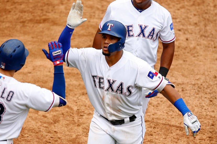Texas Rangers Carlos Gomez (center) is congratulated by Joey Gallo after his two-run homer...