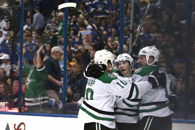 Dallas Stars Cody Eakin celebrates his overtime goal, surrounded by Patrick Sharp (left) and...
