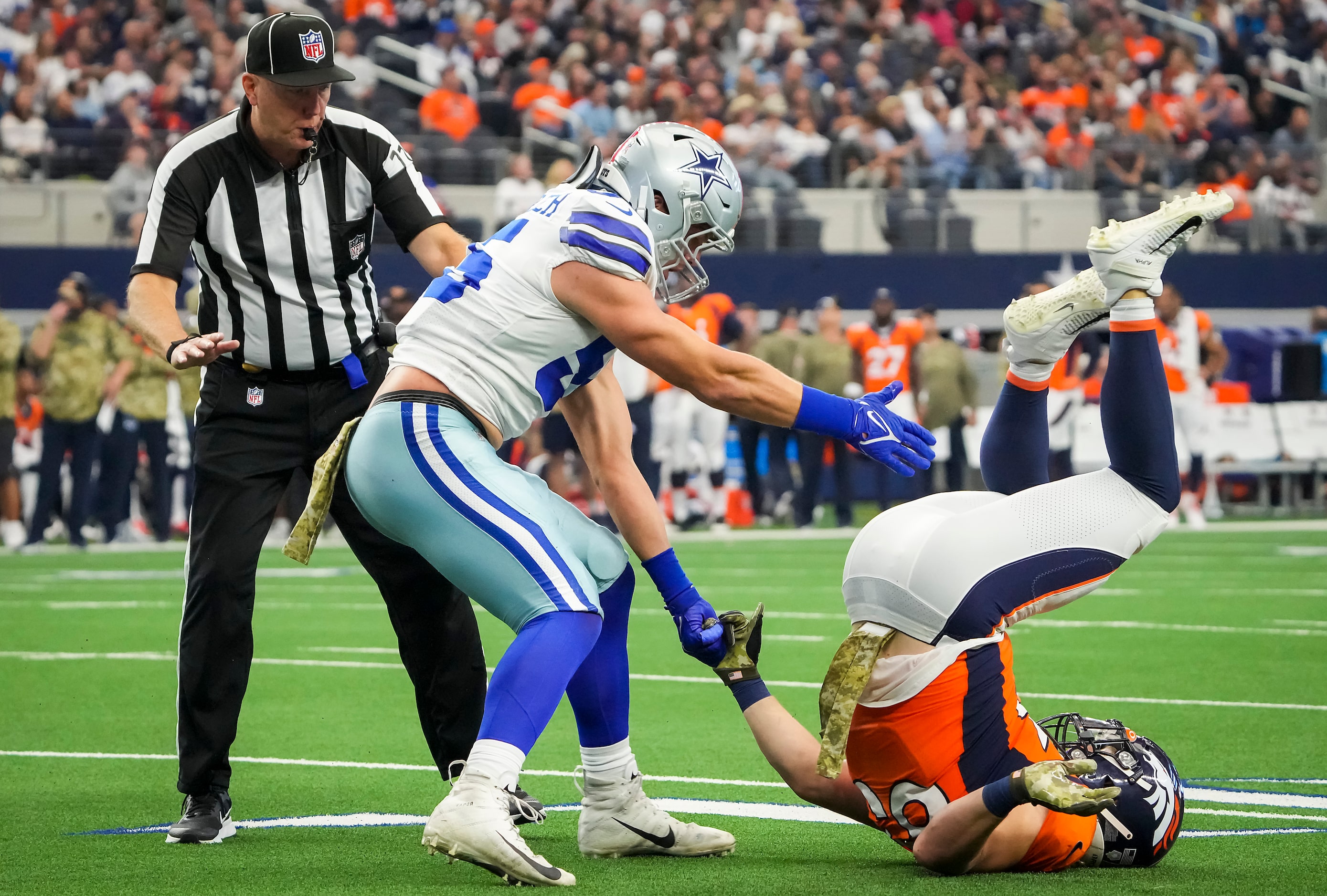 Dallas Cowboys outside linebacker Leighton Vander Esch (55) tries to help up Denver Broncos...